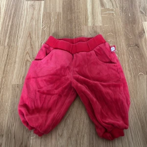 Röda mjukisbyxor från Kaxs - Säljer ett par röda mjukisbyxor från Kaxs. Byxorna har en elastisk midja och är tillverkade i ett mjukt material som ger en bekväm passform. Perfekta för en avslappnad dag hemma.