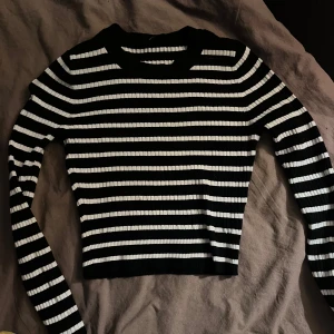 Svart och vit randig tröja - Betalas via swish! Säljer en snygg svart och vit randig tröja i ribbat material. Den är croppad och har långa ärmar, perfekt för både vardag och fest. Passar bra till jeans eller kjol för en stilren look. Hör av dig vid intresse!