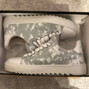 Numeris (Cloud) - Säljer ett par snygga sneakers från Numeris i grått och vitt med coolt mönster. De är i nytt skick och är använda 3 gånger. De kommer med originalförpackning, påse och extra snören. Perfekta för både vardag och fest! Storlek och passform är normal.