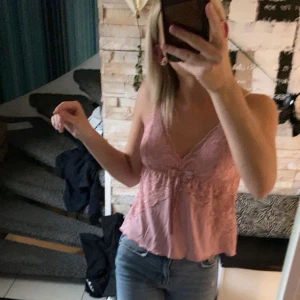 Rosa spetslinne - Säljer ett sött rosa linne med spetsdetaljer och en söt rosett. I mycket bra skick! 