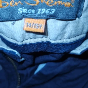 Mörkblå byxor från Ben Sherman - Snygga mörkblå byxor från Ben Sherman, perfekta för en stilren look. Byxorna har en klassisk passform med dragkedja och knapp framtill. Tillverkade i ett bekvämt material som passar till många tillfällen.