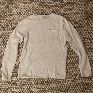 Vit långärmad tröja från Bay City - Säljer en stilren vit långärmad tröja från Bay City. Den har en enkel bröstficka och är perfekt för både vardag och avslappnade tillfällen. Tröjan är i bra skick och passar perfekt till höst- och vårgarderoben. Skön och lätt att matcha med andra plagg!