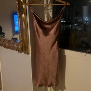 Oanvänd satin klänning från ASOS -   Säljer denna eleganta klänning från ASOS i storlek 34. Klänningen är helt oanvänd och i perfekt skick. Passar perfekt för festliga tillfällen eller en stilfull vardag. 	 Hör av dig om du är intresserad!.