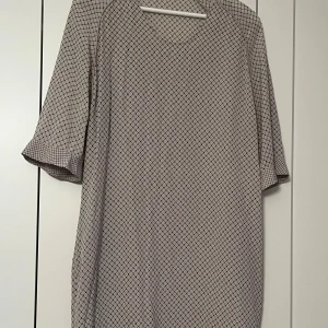 Custommade Beige klänning med rutigt mönster - Beige klänning med ett diskret rutigt mönster. Klänningen har trekvartsärmar och en bekväm passform. Nyskick. Nypris ca 1500kr. 