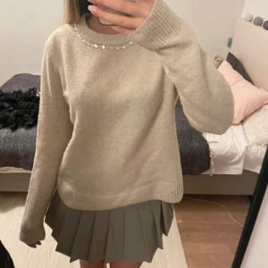 Beige tröja med pärldetaljer - Säljer en beige tröja från HM med pärldetaljer runt halsringningen. 