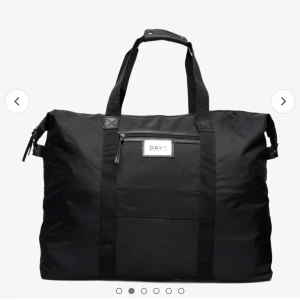 DAY ET väska  - Stor och rymlig svart shoppingväska från DAY ET. Tillverkad i slitstarkt syntetmaterial med praktiska handtag och en dragkedja för säker förvaring. Perfekt för att bära med sig allt man behöver under dagen. 