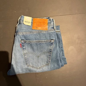 Helt nya Levi's 501 jeans i ljusblå denim - Säljer ett par klassiska Levi's 501 jeans i ljusblå denim. De har en straight passform och är högmidjade med slitna detaljer på framsidan. Perfekta för en avslappnad stil. Tillverkade i 100% bomull. Nypriss 1349 mitt endast 500. 