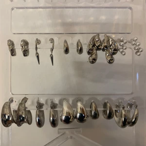 9st par örhängen i rostfritt silver stål - Nio par super fina örhängen i rostfritt silver stål. (Alla på bilden förutom den längst ner till höger på första bilden) Alla har olika skick men alla är i hyfsat bra skick och alla har lite olika ploppar som syns på de sista bilderna🌸 som man kan se har ett av hop örhängena fått lite röd färg på sig man ser det på det sista bilderna längst ner till höger men annars är alla andra helt rostfria och ska vara det!🌸🌸💓💓 Vissa är från glitter, stainless me, Lily and Rose och massa annat.
