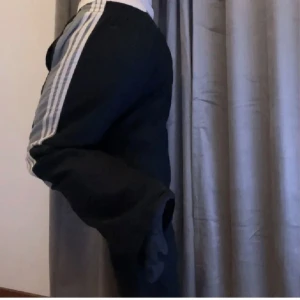 Marinblåa adidas byxor  - Säljer ett par marinblåa adidas byxor. Byxorna har en bekväm lös passform och elastisk midja. Dem är långa men har band där nere som går att spänna till om det behövs.