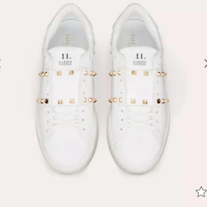 Vita sneakers med nitar från Valentino - Snygga vita sneakers från Valentino med guldnitar som ger en cool touch. Skorna har snörning och är tillverkade i skinn. Perfekta för att lyfta din stil med en lyxig känsla. De er 100% ektq✅