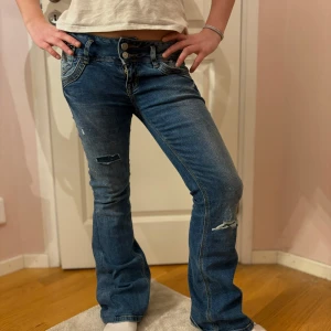 Blå bootcut jeans  - Säljer nu mina super snygga blå bootcut jeans då det inte kommer till användning. De har en lågmidjad passform och flera knappar i midjan. 