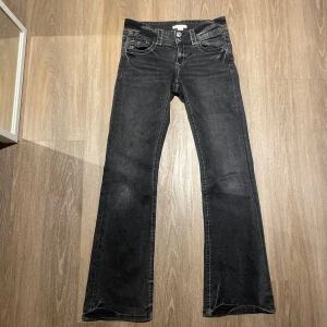 Svarta jeans från Gina Tricot - Svarta bootcut jeans med vita sömmar