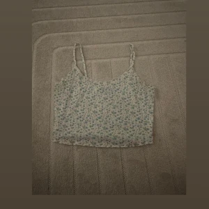 Blommigt linne - Söt blommigt linne med tunna axelband perfekt för varma sommardagar.