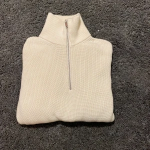Beige stickad quarter zip från H&M - Säljer en beige stickad quarter zip från H&M i perfekt skick. Tröjan är endast använd en gång