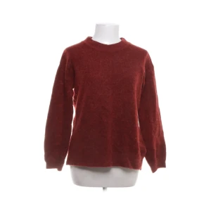 Röd stickad tröja från Indiska - Mysig röd stickad tröja från Indiska i storlek S. Perfekt för kyliga dagar med sin varma och bekväma design. Tröjan har långa ärmar och en klassisk rund halsringning.