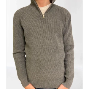 Grå stickad tröja med dragkedja - Säljer en stilren grå stickad tröja med dragkedja vid halsen. Perfekt för kyligare dagar och passar bra till både jeans och chinos. Tröjan har långa ärmar och en ribbad struktur som ger en klassisk look.