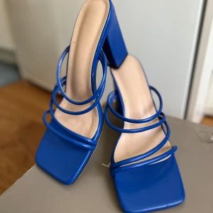 Blå sandaler med klack - Snygga blå sandaler med fyrkantig tå och flera remmar över foten. Perfekta för att ge en färgklick till din outfit.