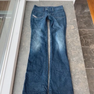 Blå jeans med bootcut - Snygga blå Diesel jeans med bootcut-stil och låg midja. Försmå så har ingen bild på. Slitningar längst ner på benet. Innebenslängd:88cm Midjemått:39cm  ❗️Lånadebilder❗️