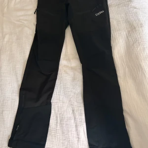 Svarta byxor från Strova - Svarta friluftbyxor från Strøva i storlek XS. Mycket bra skick och mycket sköna. Använda 4-5 gånger. Lite slitage på knappen på bild 3 men inget man tänker på så mycket. 