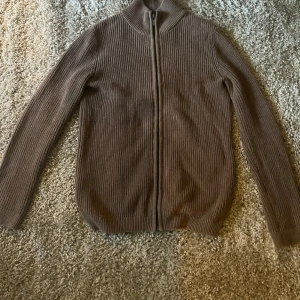 Brun stickad kofta. Dressman  - Säljer en stilren brun stickad tröja. Sitter bra för folk som är 183-187. 