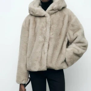 Zara pälsjacka💗 - Säljer en supermjuk och fluffig beige pälsjacka med huva. Jackan har en avslappnad passform och långa ärmar, perfekt för kyliga dagar. Den är både stilren och bekväm, vilket gör den till ett måste i garderoben.