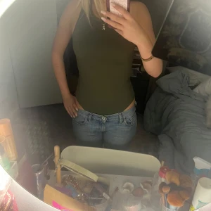 Olivgrön ärmlös body  - Säljer en stilren olivgrön ärmlös body. Perfekt för en finare look. Bodyn är lite för stor för mig och är tillverkad i ett mjukt material som sitter skönt mot kroppen. Har två och den är lite för stor därför säljs. Från hm.💘