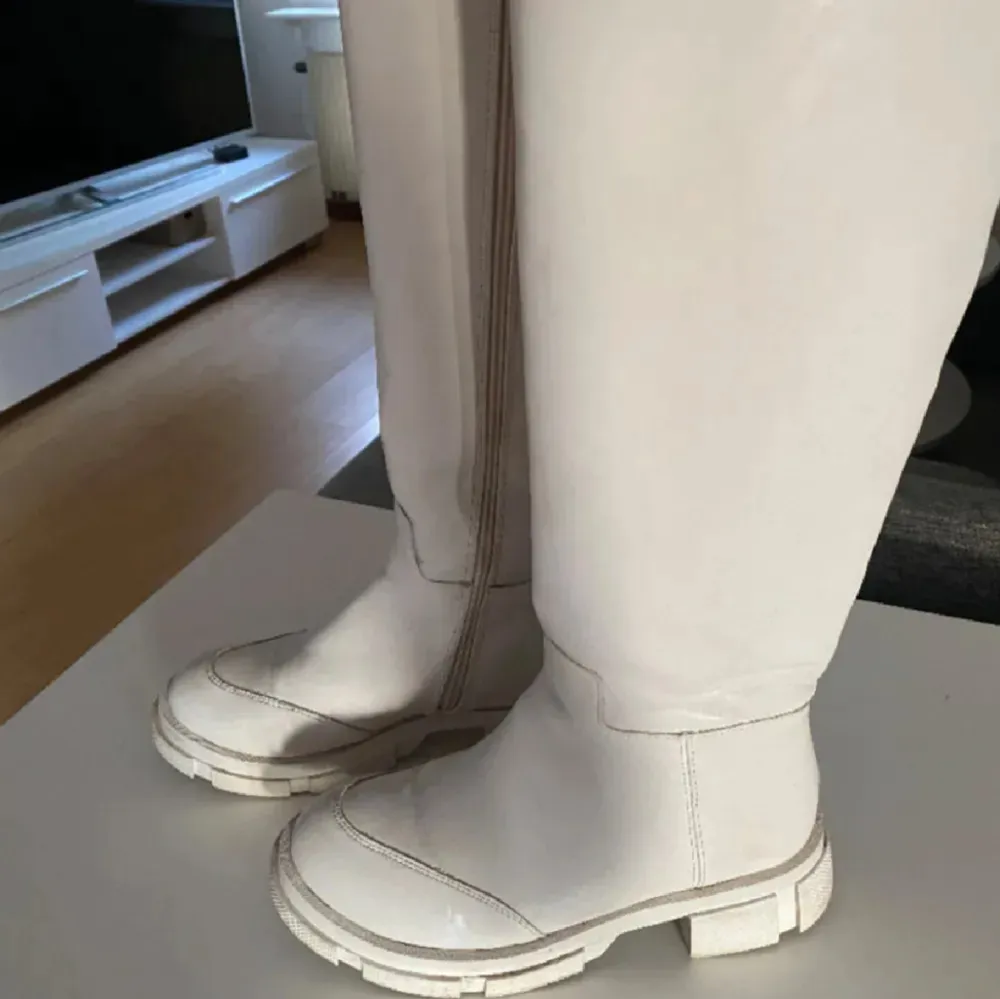 Snygga vita stövlar med dragkedja på sidan. De har en robust sula och är perfekta för en stilren look. Passar bra till både vardag och speciella tillfällen. Köpt från en butik i Leksand, nypris 1000:-. Kengät.