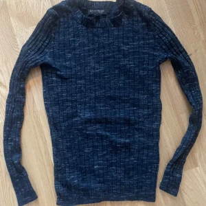 Mörkgrå ribbad tröja från Banana Republic stl S - Säljer en stilren mörkblå ribbad tröja från Banana Republic i 100% merinoull. Tröjan har långa ärmar och en klassisk passform som passar perfekt för kyligare dagar. Perfekt för dig som älskar både stil och komfort.