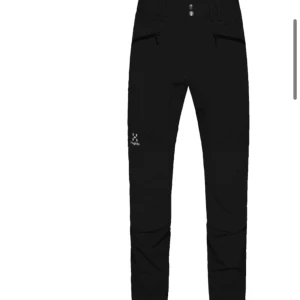 Haglöfs byxor  - Snygga svarta byxor från Haglöfs med dragkedja och knappar. Perfekta för utomhusaktiviteter med en stilren design. Byxorna har en normal passform och är tillverkade i slitstarkt material. Nya dessutom 