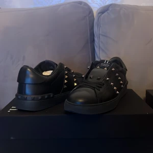  valentinos  skor  - Snygga svarta sneakers med nitar som ger en edgy look. Skorna har en klassisk design med snörning och är perfekta för att lyfta vilken outfit som helst.