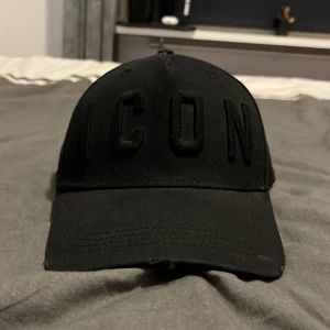 Svart keps från Dsquared2 - Snygg svart keps från Dsquared2 med texten 'ICON' broderad framtill. Kepsen har en justerbar rem baktill för perfekt passform. Pris kan diskuteras vid snabb affär