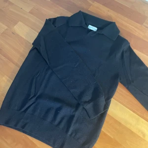 Marinblå tröja från These Glory Days - Snygg svart tröja från These Glory Days i mjukt MERINO ULL. Perfekt för en stilren look med krage och långa ärmar. Passar bra till både vardag och mer uppklädda tillfällen. Den är också varm och extra skön nu till de kalla vinterdagarna! Den passa någon som är mellan 160-169cm. Skicket är även väldigt bra 9,5/10.