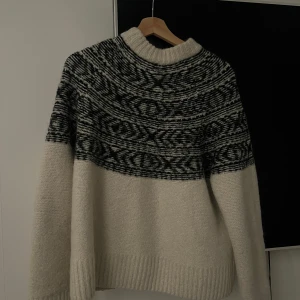 Vit och svart stickad tröja - Mysig stickad tröja i vitt med ett svart mönster runt halsen. Väldigt varm och passar perfekt nu till vintern!