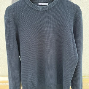 Marin blå stickad tröja Zara - Säljer en stilren marinblå stickad tröja från Zara. Tröjan har en klassisk rund hals och långa ärmar, perfekt för kyligare dagar. Tröjan är använd ett par gånger men den är så gott som ny.