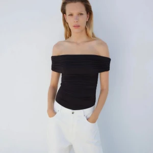 Svart offshoulder body - Snygg svart offshoulder bodysuit med tight passform. Materialet är stretchigt och bekvämt. Omvänd 