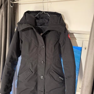 Canada goose vinterjacka  - Säljer en dunjacka av märket Canada Goose i modellen Rossclair parka. Köpt på johnells för två vintrar sedan, användes under ca en månad den vintern men kommer ej till användning mer. Pälskrage till huvan medkommer. Varm jacka i en snygg figursydd modell som garanterat håller en varm de kallaste vinterdagarna 😍Storlek S. Äkthetsbevis finns. Pris kan bli disskuterbart. Hör av dig vid intresse! 