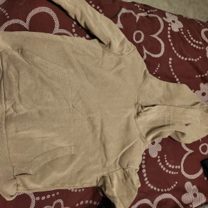 Beige hoodie med ficka - Säljer en stilren beige hoodie med en praktisk magficka och huva. Perfekt för en avslappnad look. Passar bra till både jeans och mjukisbyxor.