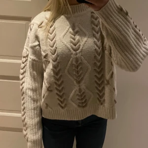 Beige stickad tröja med flätmönster - Säljer denna super gosiga stickade tröjan. Tröjan passar perfekt nu till jul❣️Har använt tröjan en gång och den kommer inte mer till användning. Tröjan är i storlek M men passar mej bra som annars är storlek S. Tröjan är från boohoo och köppt för ungefär 30€