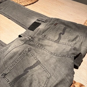 Nudie Jeans - Säljer ett grått par nudie jeans i storlek W29 L32 samt i mycket bra skick. Modellen är grim tim som har en slim passform. Hör av dig vid minsta fundering! 😊