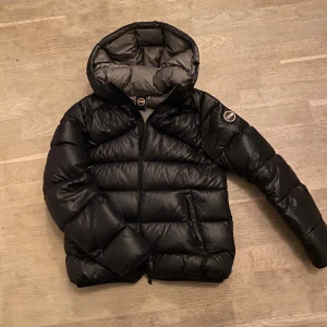 Svart dunjacka /pufferjacka från Colmar - Säljer en snygg svart dunjacka från Colmar med huva och dragkedja. jackan är Något liten för mig som är 169cm, men det är smaksak! Mina egna bilder+hur dem sitter på mig🙌Ser inga defekter,men tecken på användnig🙌 Hittar ej storleken, men jag bär xs/s!  Pris går att diskuteras lite vid snabb affär🙌nypris runt:5500kr Man får själv avgöra skicket på jackan via bilderna, men ser ej som sagt inga defekter på Jackan, lite missfärgningar på insida av jackan, ser inga på utsida, säljer pga för liten!