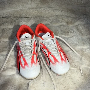 Vita och röda fotbollsskor från Puma - Snygga fotbollsskor från Puma i vitt och rött med svart detalj. Skorna har snörning och en sportig design som passar perfekt för fotbollsplanen. ❤️❤️ jag skriver adress när ni vill ha dom!!