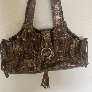 Unik väska i metallic mönster - Supersnygg men kmr tyvärr inte till användning, bra skick förutom en fläck på lappen på insidan!