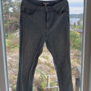 Blå jeans från H&M - Säljer ett par klassiska blå jeans från H&M i storlek 42. De har en snygg tvätt och är i bra skick. Perfekta för vardagsbruk och kan matchas med nästan vad som helst. De har en knapp och dragkedja framtill samt fickor både fram och bak.