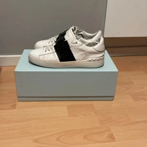 Vita sneakers med svart detalj - Säljer ett par valentino opens, skick 9/10,vid någtw funderingar och frågor är de bara och höra av er ,ny pris 7200 kr. Kan gå ner i pris vid snabb affär 