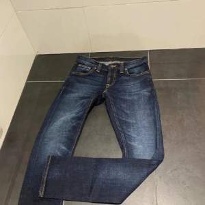 Ett par riktigt snygga och stilrena mörkblåa  nudie jeans i storlek W27 L30. Skicket är extremt bra och de passar någon som är runt 165 till 175. Säljer då dem inte längre kommer till användning. Priset är inte hugget i sten.👍