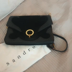 Sandro Väska - Sandro-väska säljes Elegant väska från Sandro. Något sliten vid låset, men annars i gott skick. Priset kan såklart diskuteras vid snabb och smidig affär Kan hämtas i Stockholm. Kan även skickas 