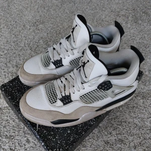 Air Jordan 4 Retro - Storlek 44,5. Färg white/black-neutral grey. Skorna är i använt skick.