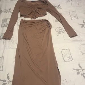 Set - Säljer en fin set,  storleken på kjolen och tröjan är XS, kjolen har en slits och är lång