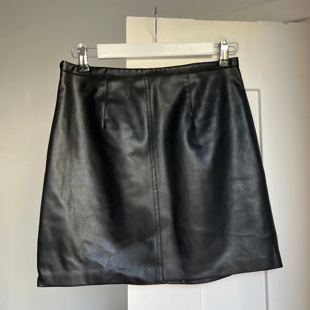 Snygg svart kjol i skinnimitation från Cubus. Klassisk, rak, tajt passform med ”osynlig” dragkedja. Normal i storlek XS/34. Hameet.