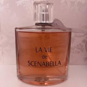 La Vie de Scenabella Parfym - La Vie de Scenabella är en kvinnlig parfym med en blommig och fruktig doft. Toppnoter: svartvinbär och päron Mellannoter: iris och jasminblomma Basnoterna: patchouli, lingling vaniljböna och vaniljsocker. Nytt skick UTAN förpackning, 100ml